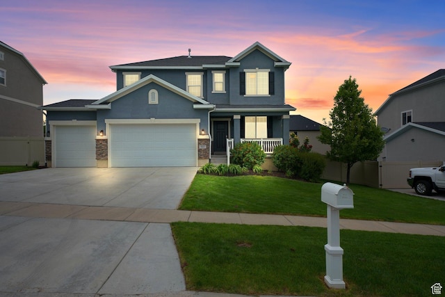 512 W Kit Fox Dr Unit 616, Saratoga Springs, UT 84045 - traditional home with stucco siding, a garage, concrete driveway, a porch, and stone siding