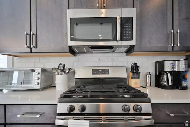 1097 W Wasatch Spring Rd, Kamas, UT 84036 - kitchen featuring stainless steel appliances, light countertops, decorative backsplash, and dark brown cabinets