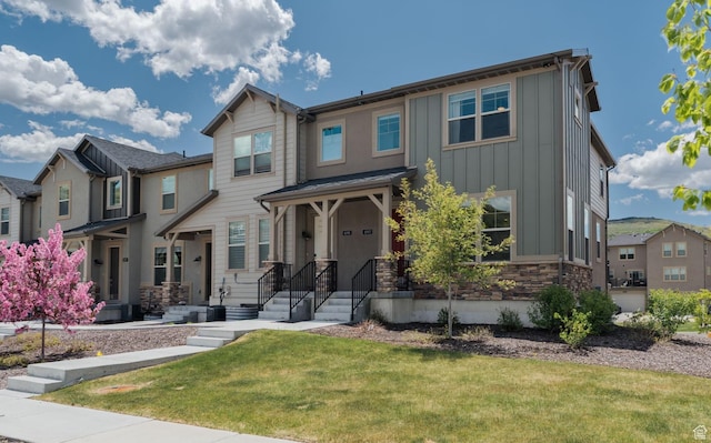 1097 W Wasatch Spring Rd, Kamas, UT 84036 - view of front of home featuring board and batten siding, a residential view, a front lawn, and stone siding