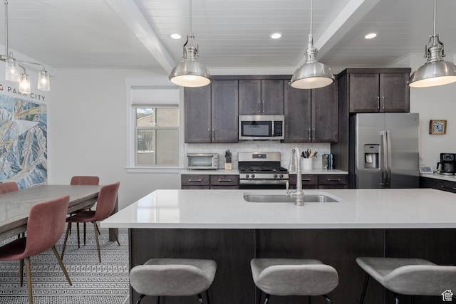 1097 W Wasatch Spring Rd, Kamas, UT 84036 - kitchen featuring stainless steel appliances, a sink, a breakfast bar area, beamed ceiling, and light countertops