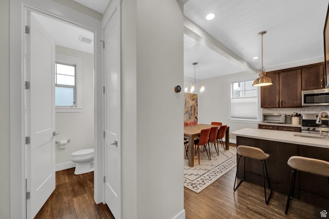 1097 W Wasatch Spring Rd, Kamas, UT 84036 - kitchen with appliances with stainless steel finishes, dark brown cabinetry, dark wood-style flooring, baseboards, and beamed ceiling