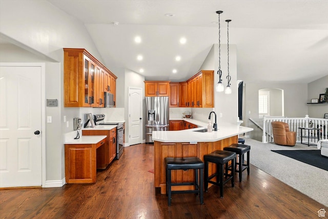 774 W 2300 S, Syracuse, UT 84075 - kitchen with stainless steel appliances, brown cabinetry, vaulted ceiling, a peninsula, and arched walkways