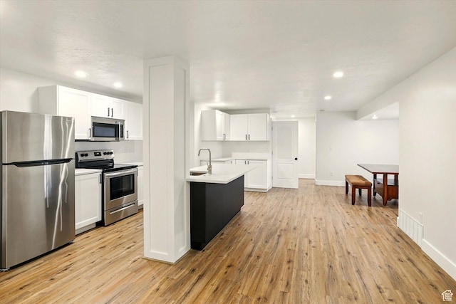 774 W 2300 S, Syracuse, UT 84075 - kitchen with appliances with stainless steel finishes, light wood-style flooring, light countertops, white cabinets, and recessed lighting
