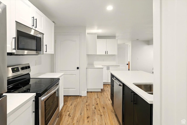 774 W 2300 S, Syracuse, UT 84075 - kitchen with appliances with stainless steel finishes, light wood finished floors, white cabinetry, light countertops, and a sink
