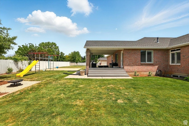 774 W 2300 S, Syracuse, UT 84075 - rear view of house featuring an outdoor fire pit, a playground, brick siding, a patio area, and a shingled roof