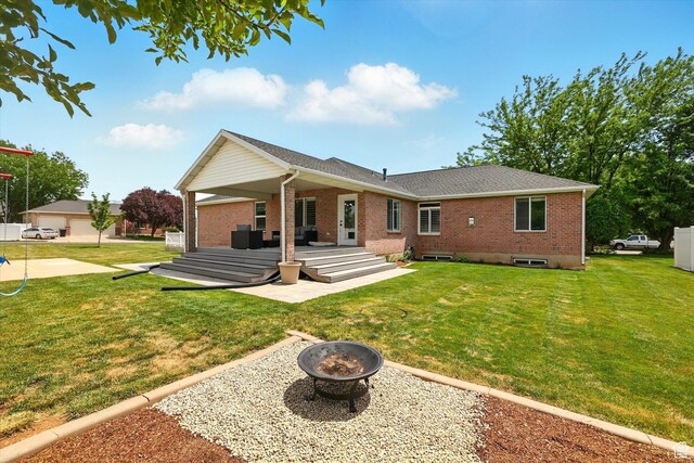 774 W 2300 S, Syracuse, UT 84075 - rear view of property with an outdoor fire pit, brick siding, a yard, and a patio