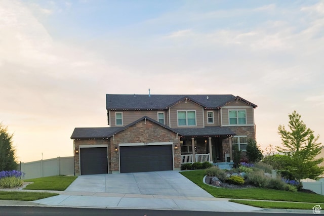 5284 W Orchard Spring Dr S, Herriman, UT 84096 - view of front of property with covered porch, an attached garage, stone siding, and concrete driveway