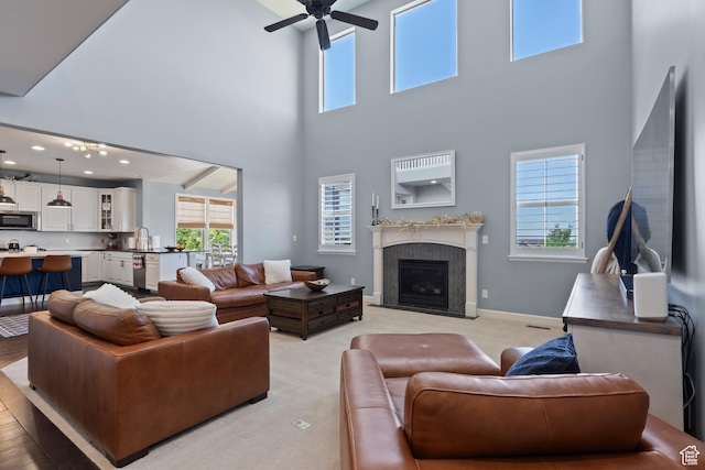 5284 W Orchard Spring Dr S, Herriman, UT 84096 - living room with a towering ceiling, a ceiling fan, a fireplace with flush hearth, and baseboards