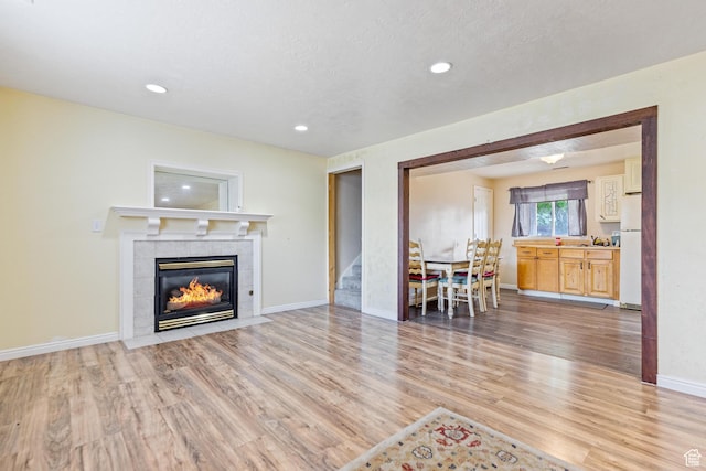 773 W 1280 S, Provo, UT 84601 - living area featuring light wood finished floors, a tiled fireplace, recessed lighting, stairs, and baseboards