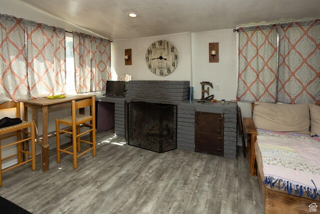 40 S Main St, Glenwood, UT 84730 - bedroom featuring wood finished floors, a brick fireplace, a textured ceiling, and a sink