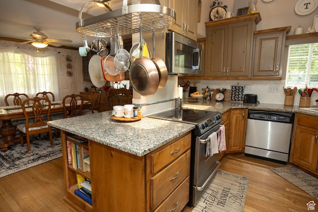 40 S Main St, Glenwood, UT 84730 - kitchen with appliances with stainless steel finishes, light wood-style flooring, ceiling fan, and tasteful backsplash