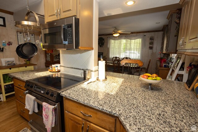 40 S Main St, Glenwood, UT 84730 - kitchen with stainless steel microwave, electric range, ceiling fan, light stone counters, and decorative backsplash