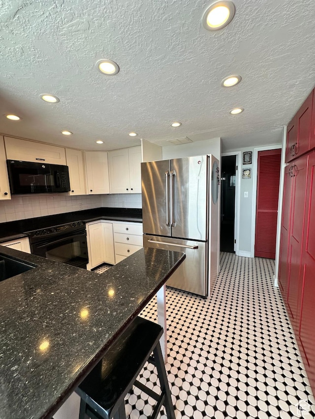241 N Vine St W Unit 808W, Salt Lake City, UT 84103 - kitchen with freestanding refrigerator, black microwave, decorative backsplash, a textured ceiling, and recessed lighting