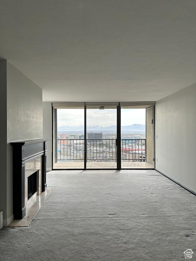 241 N Vine St W Unit 808W, Salt Lake City, UT 84103 - unfurnished living room with carpet flooring, a premium fireplace, expansive windows, and baseboards