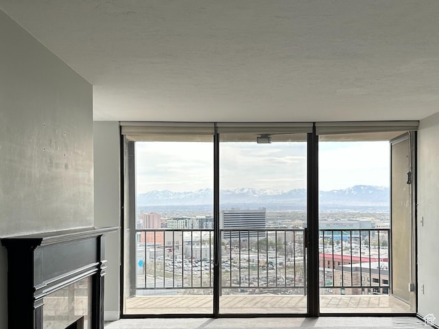 241 N Vine St W Unit 808W, Salt Lake City, UT 84103 - interior space featuring floor to ceiling windows, a mountain view, baseboards, a textured ceiling, and a city view