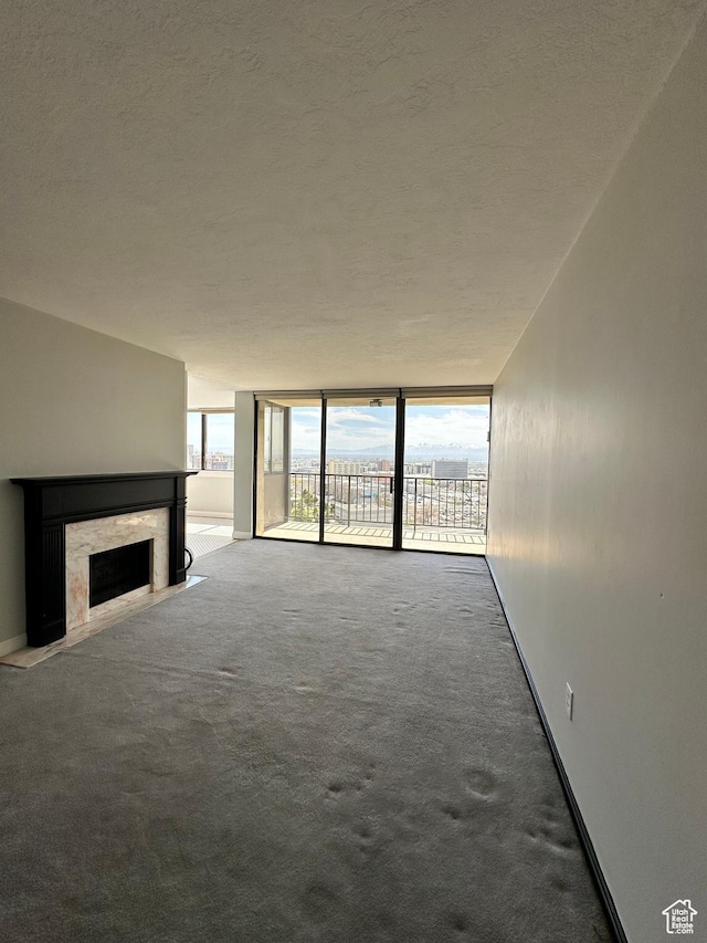 241 N Vine St W Unit 808W, Salt Lake City, UT 84103 - unfurnished living room featuring a textured ceiling, a fireplace, carpet, and a wall of windows