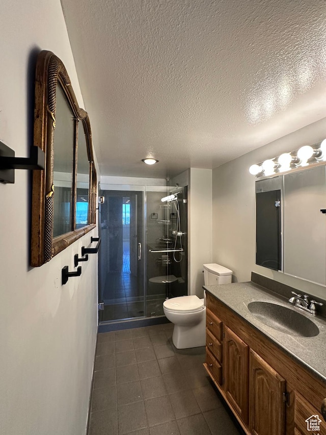 241 N Vine St W Unit 808W, Salt Lake City, UT 84103 - bathroom featuring a textured ceiling, vanity, a shower stall, and tile patterned flooring