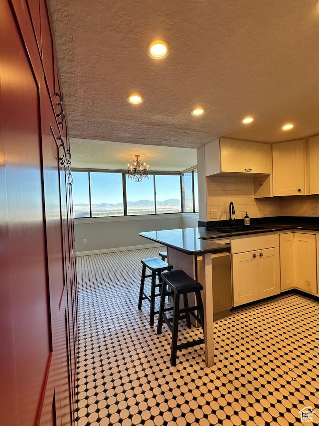 241 N Vine St W Unit 808W, Salt Lake City, UT 84103 - kitchen featuring dark countertops, recessed lighting, a chandelier, a textured ceiling, and stainless steel dishwasher