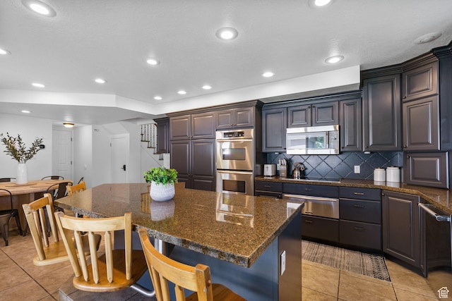 993 E 12600 S, Draper, UT 84020 - kitchen with appliances with stainless steel finishes, a warming drawer, a breakfast bar, a center island, and backsplash