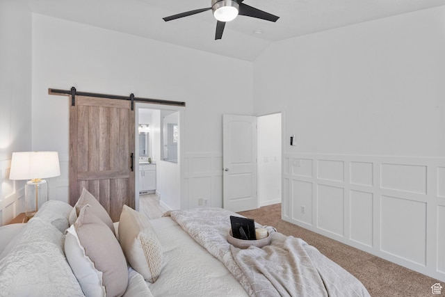 13226 S Cocomo Ct W, Herriman, UT 84096 - bedroom featuring a barn door, light colored carpet, a wainscoted wall, ensuite bathroom, and a ceiling fan
