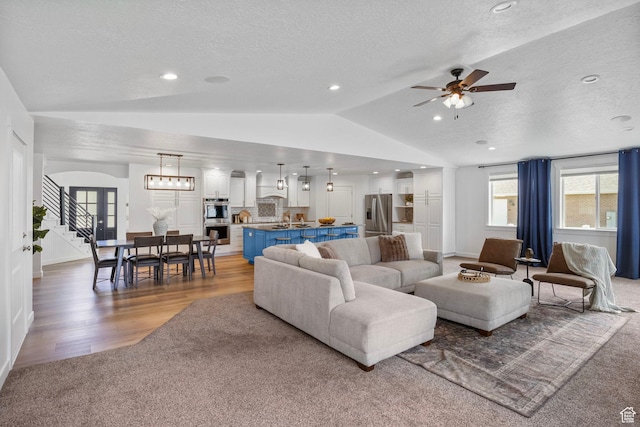 13226 S Cocomo Ct W, Herriman, UT 84096 - living room with vaulted ceiling, a textured ceiling, a ceiling fan, light wood-style floors, and baseboards