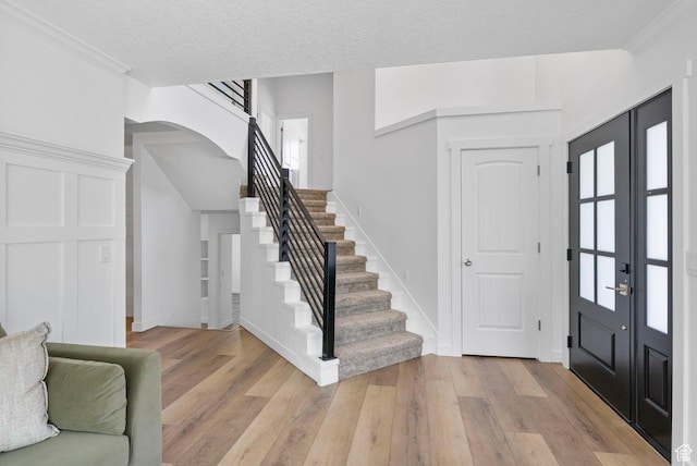 13226 S Cocomo Ct W, Herriman, UT 84096 - entryway featuring stairs, light wood-style flooring, arched walkways, baseboards, and ornamental molding