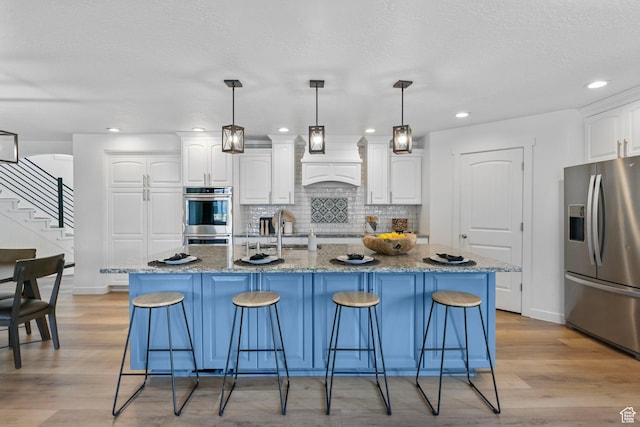 13226 S Cocomo Ct W, Herriman, UT 84096 - kitchen featuring stainless steel appliances, white cabinetry, decorative backsplash, a breakfast bar area, and recessed lighting