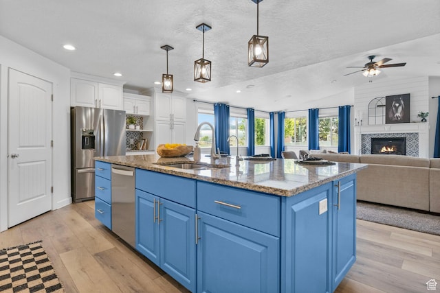 13226 S Cocomo Ct W, Herriman, UT 84096 - kitchen with blue cabinets, a sink, stainless steel appliances, white cabinetry, and light wood-style flooring