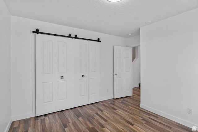 13226 S Cocomo Ct W, Herriman, UT 84096 - unfurnished bedroom with baseboards, wood finished floors, a textured ceiling, and a closet