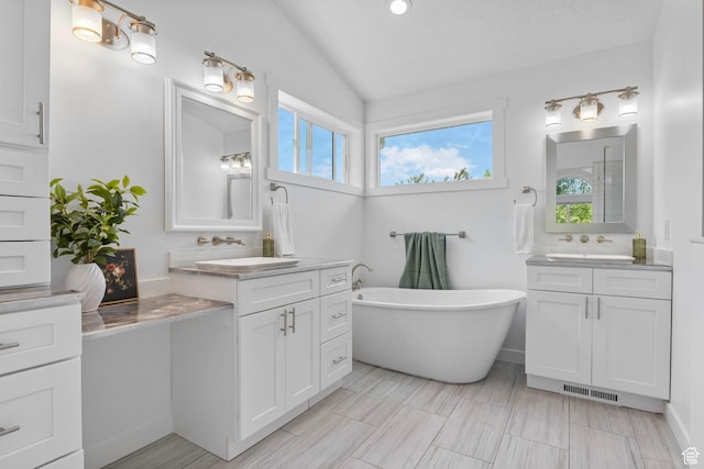 13226 S Cocomo Ct W, Herriman, UT 84096 - bathroom with lofted ceiling, two vanities, a soaking tub, and a shower