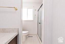 330 N 100 E, Centerfield, UT 84622 - bathroom with vanity, a stall shower, toilet, and tile patterned floors