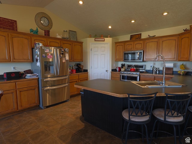 113 N 4950 W, West Point, UT 84015 - kitchen with appliances with stainless steel finishes, a sink, brown cabinets, a breakfast bar area, and vaulted ceiling