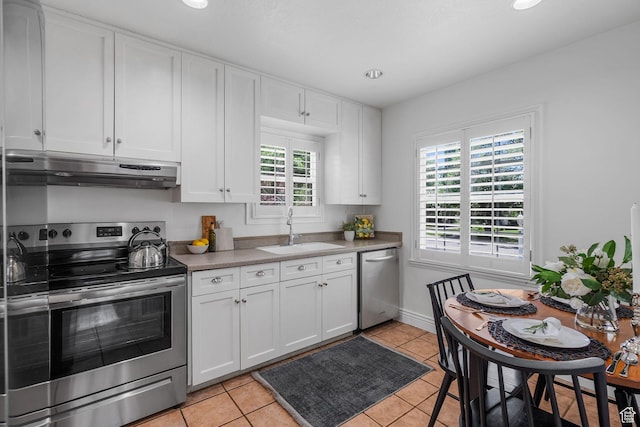 1861 E Ramona Ave, Salt Lake City, UT 84108 - kitchen with appliances with stainless steel finishes, under cabinet range hood, a sink, white cabinets, and light tile patterned floors