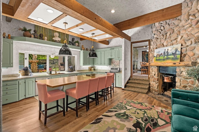 12 N Quiet Meadow Ln, Mapleton, UT 84664 - kitchen with green cabinetry, beamed ceiling, light countertops, light wood-type flooring, and a breakfast bar area