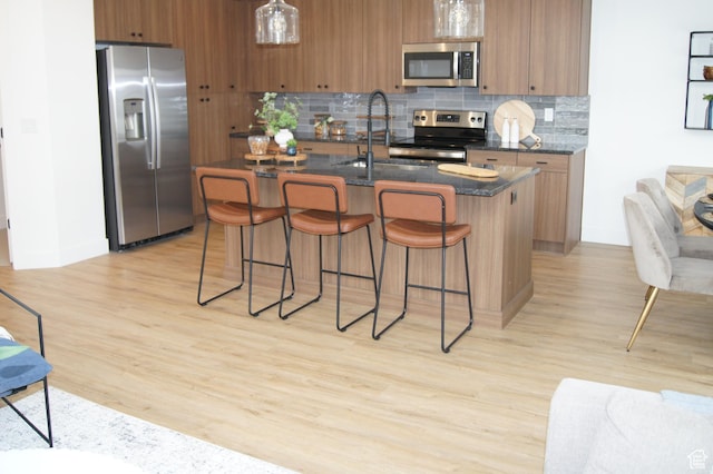 187 E 210 N Unit 7, North Salt Lake, UT 84054 - kitchen with appliances with stainless steel finishes, a sink, brown cabinets, and decorative backsplash