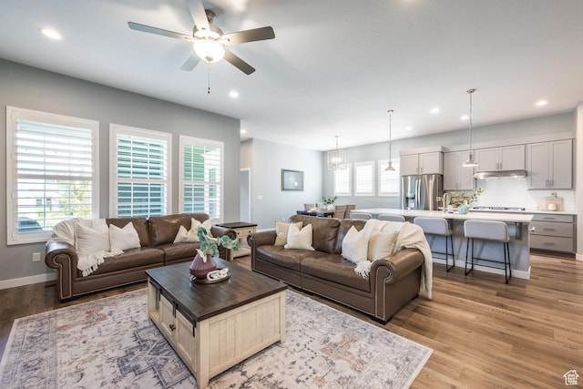 5067 W Beach Comber Way S, South Jordan, UT 84009 - living room featuring light wood-style floors, a ceiling fan, recessed lighting, and baseboards