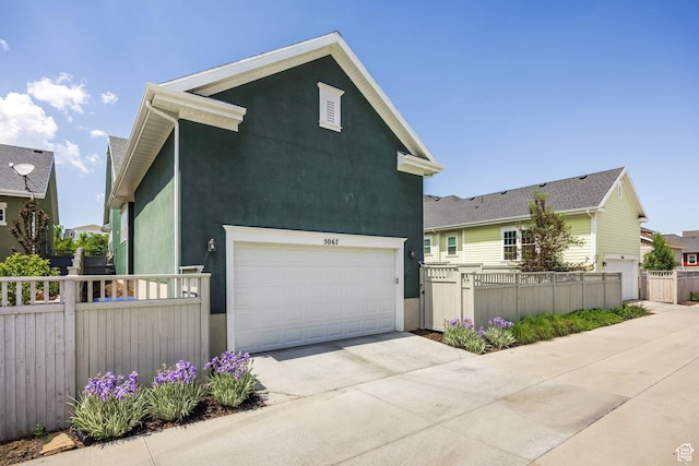 5067 W Beach Comber Way S, South Jordan, UT 84009 - view of front facade with concrete driveway, a garage, and stucco siding