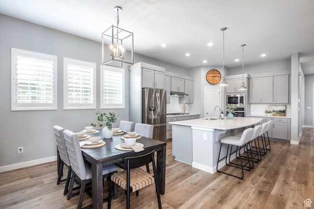 5067 W Beach Comber Way S, South Jordan, UT 84009 - dining area featuring baseboards, recessed lighting, light wood-style flooring, and a chandelier