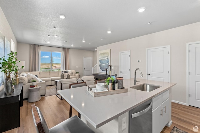 213 E 400 N Unit 980, Saratoga Springs, UT 84045 - kitchen featuring a sink, dishwasher, white cabinets, a kitchen island with sink, and light wood-style flooring
