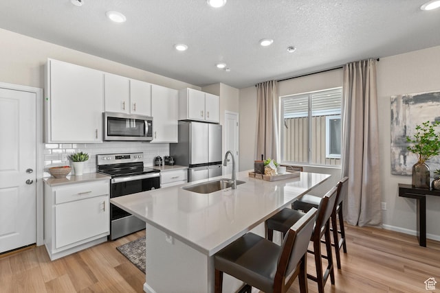 213 E 400 N Unit 980, Saratoga Springs, UT 84045 - kitchen featuring stainless steel appliances, a sink, light wood finished floors, tasteful backsplash, and recessed lighting