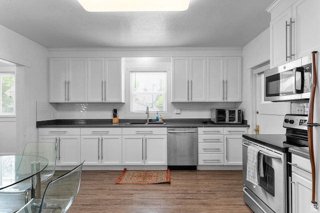 341 N 300 W, Provo, UT 84601 - kitchen with appliances with stainless steel finishes, a sink, tasteful backsplash, and dark countertops