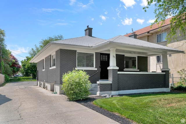 341 N 300 W, Provo, UT 84601 - view of front of home featuring a porch, a front yard, a chimney, and brick siding