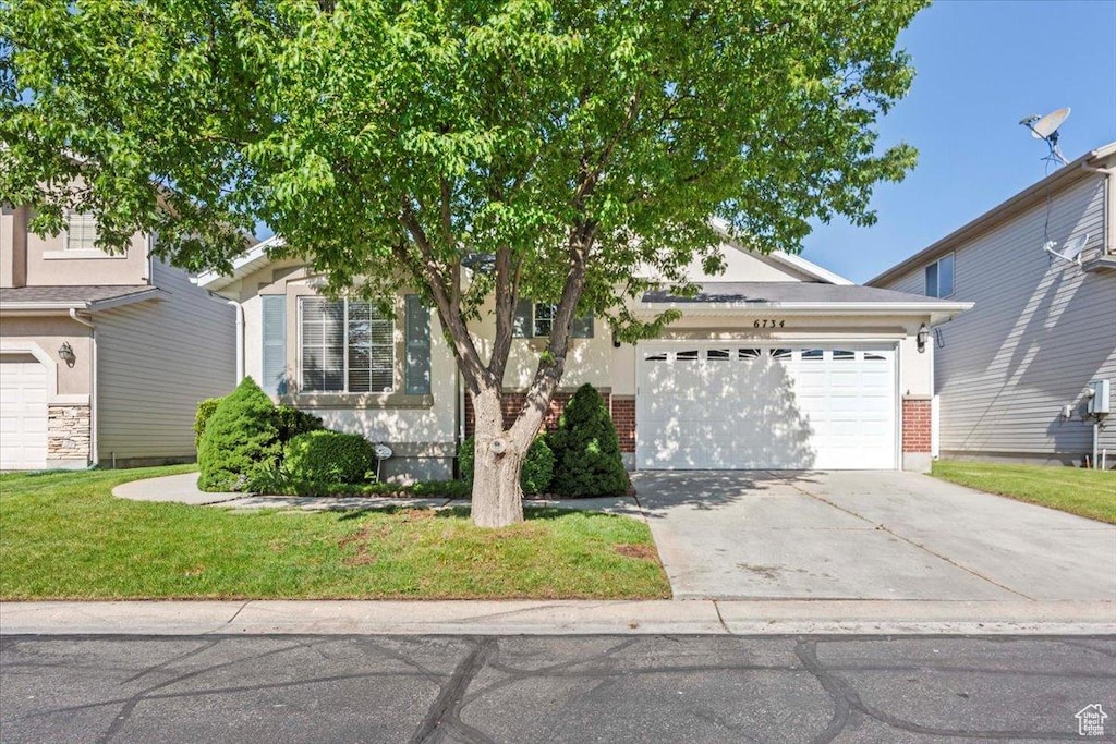 6734 S Firenze Pl, West Jordan, UT 84081 - obstructed view of property featuring an attached garage, driveway, a front lawn, and brick siding