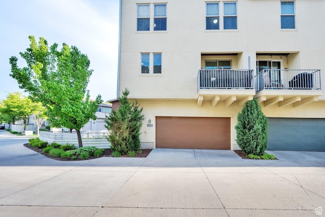 11379 S Oakmond Rd, South Jordan, UT 84009 - view of front of house featuring stucco siding, concrete driveway, an attached garage, and a balcony