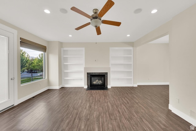 11379 S Oakmond Rd, South Jordan, UT 84009 - unfurnished living room featuring baseboards, dark wood finished floors, a fireplace, built in features, and recessed lighting