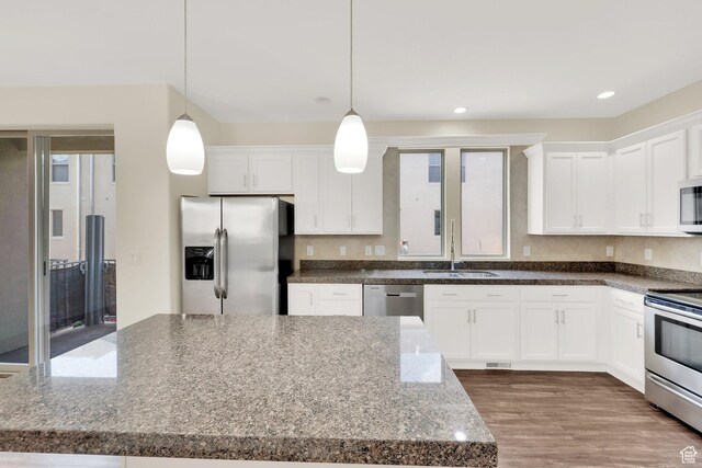 11379 S Oakmond Rd, South Jordan, UT 84009 - kitchen featuring appliances with stainless steel finishes, white cabinetry, pendant lighting, wood finished floors, and recessed lighting