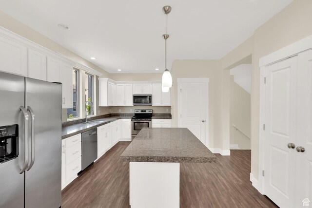 11379 S Oakmond Rd, South Jordan, UT 84009 - kitchen featuring stainless steel appliances, dark countertops, a sink, a center island, and dark wood-style floors