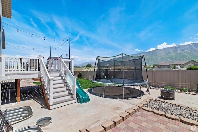 449 Travertine Way, Santaquin, UT 84655 - fenced backyard with a trampoline, a fire pit, a patio area, and a mountain view