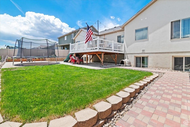 449 Travertine Way, Santaquin, UT 84655 - rear view of house with a trampoline, a wooden deck, stucco siding, and a patio