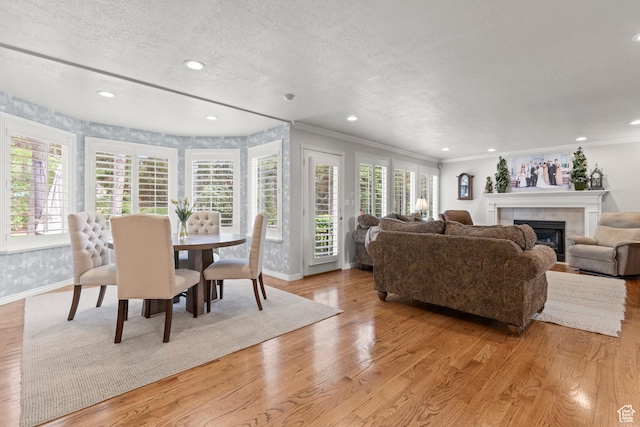 3330 N 175 W, North Ogden, UT 84414 - dining room featuring plenty of natural light, baseboards, a textured ceiling, a tiled fireplace, and light wood-type flooring